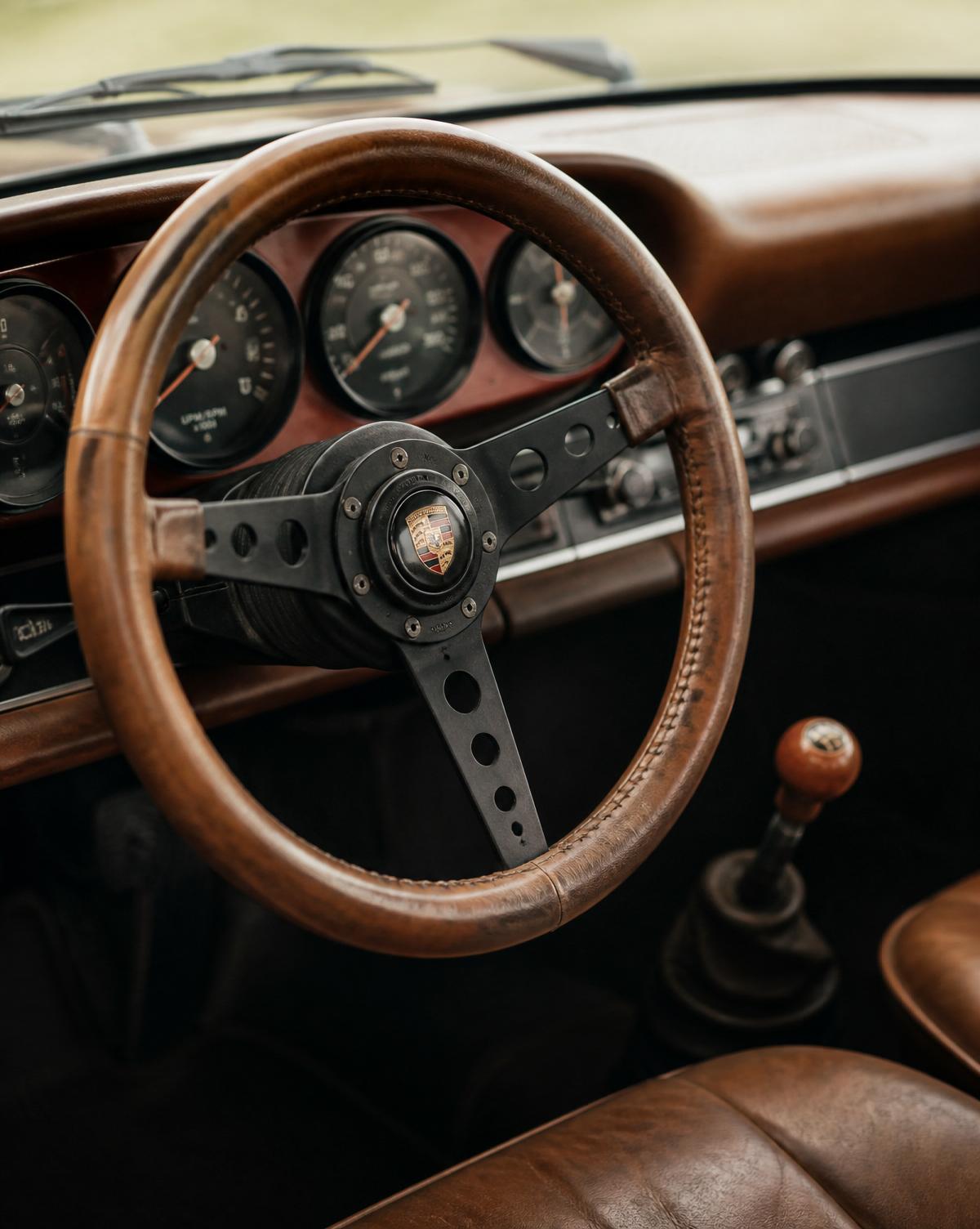 Aged wooden steering wheel of a classic Porsche 911 with vintage patina